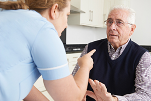 A home nurse scolding an old man